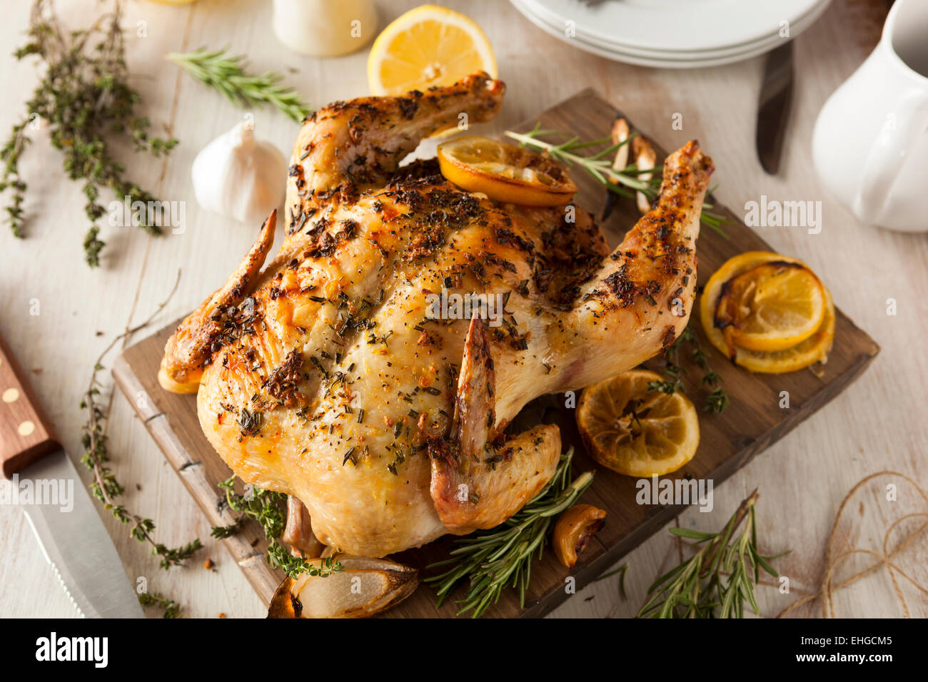 Homemade Lemon and Herb Whole Chicken on a Cutting Board Stock Photo