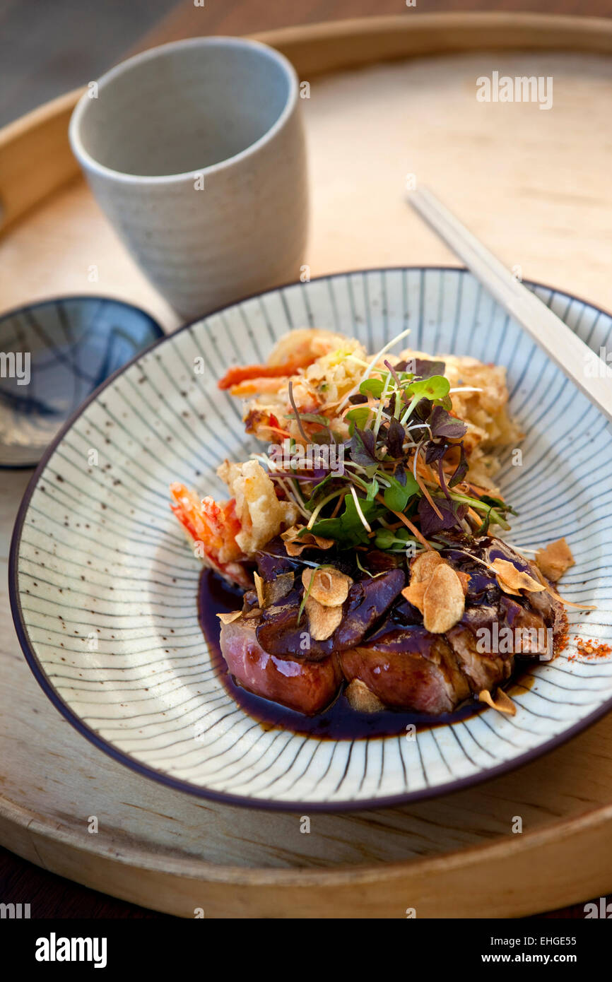 Japanese dish with beef sauce, fried vegetables, almonds and salad Stock Photo