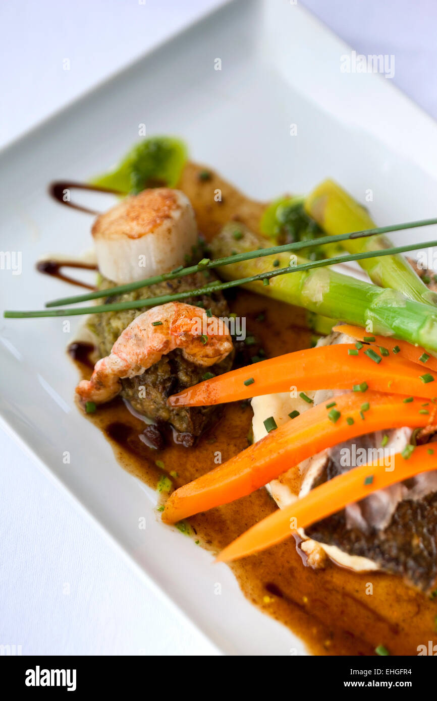 Saint-Jacques and prawns, eggplant puree and vegetables with sauce Stock Photo