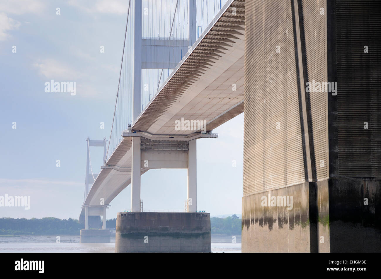 The older Severn suspension bridge spanning the Severn estuary at low tide on a sunny day Stock Photo