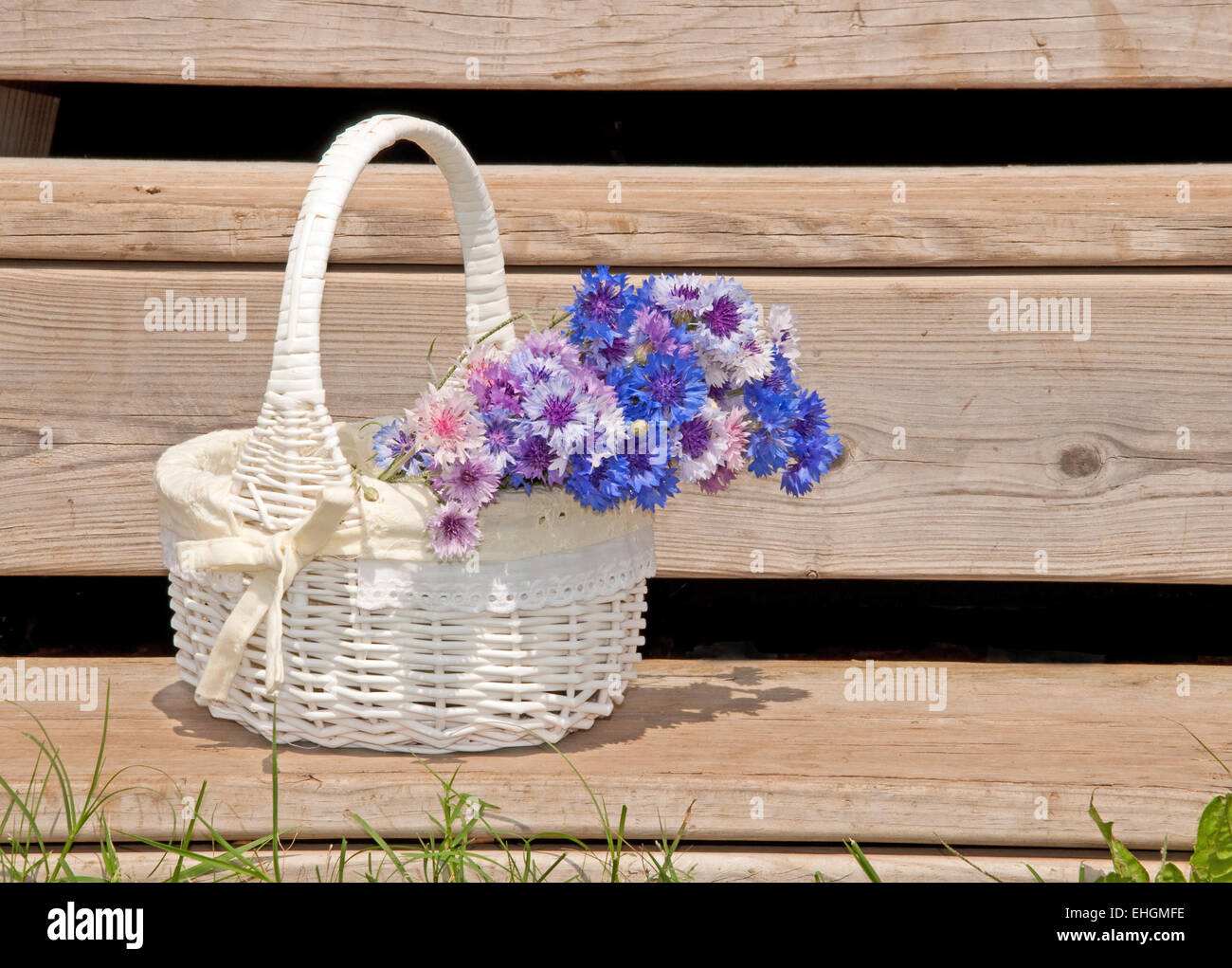 Wicker basket with flowers on rustic steps of a summer house Stock
