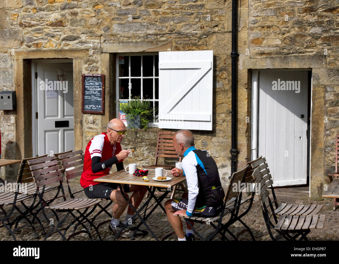 Cyclists outside cafe in village of Slaidburn in the Forest of Bowland (AONB), Ribble Valley district of Lancashire, England, UK Stock Photo