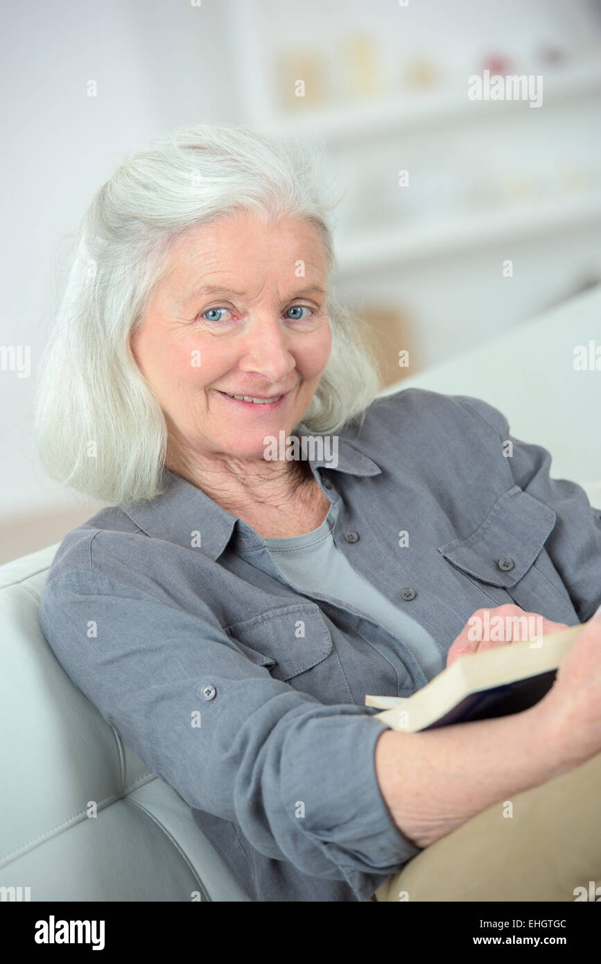Old lady reading on the sofa Stock Photo
