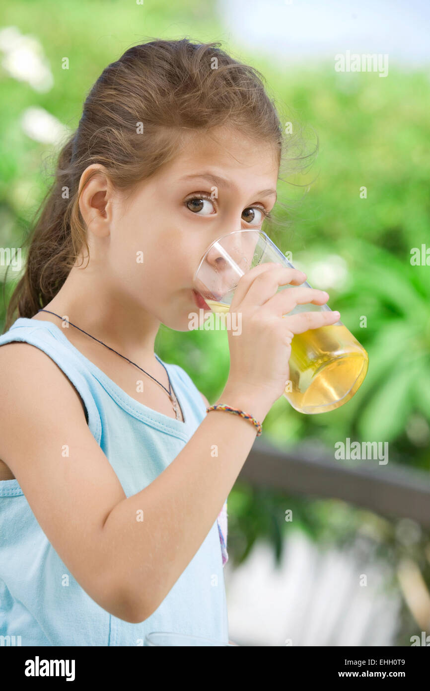 portrait of nice little girl drinking juice in summer environment Stock ...
