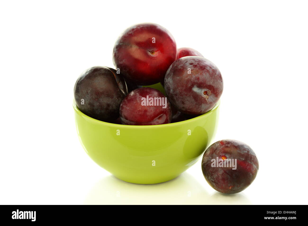 Ripe plums in green bowl. Stock Photo