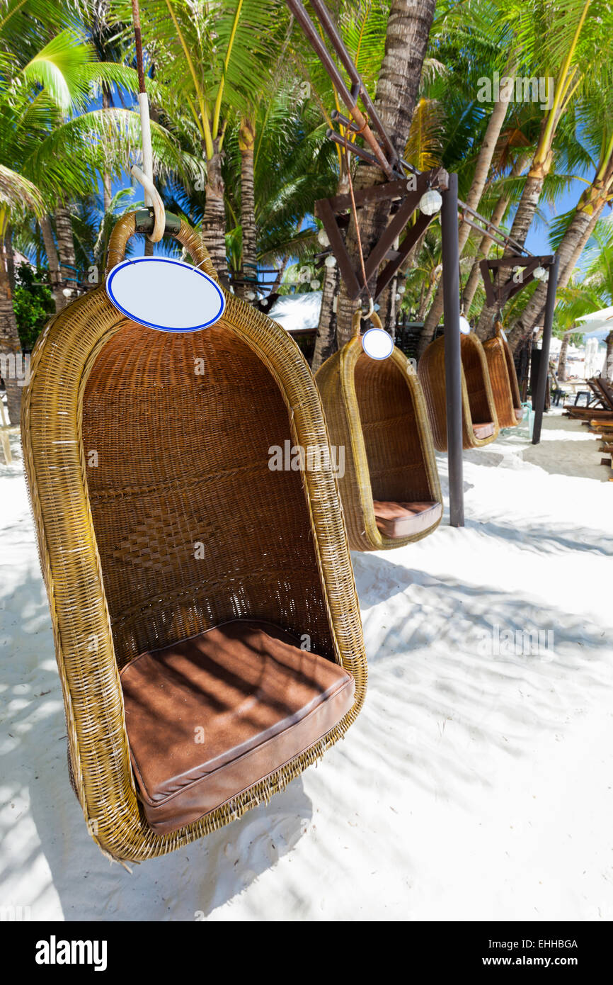 Empty hanging wicker chair on tropical beach, Philippines, Boracay