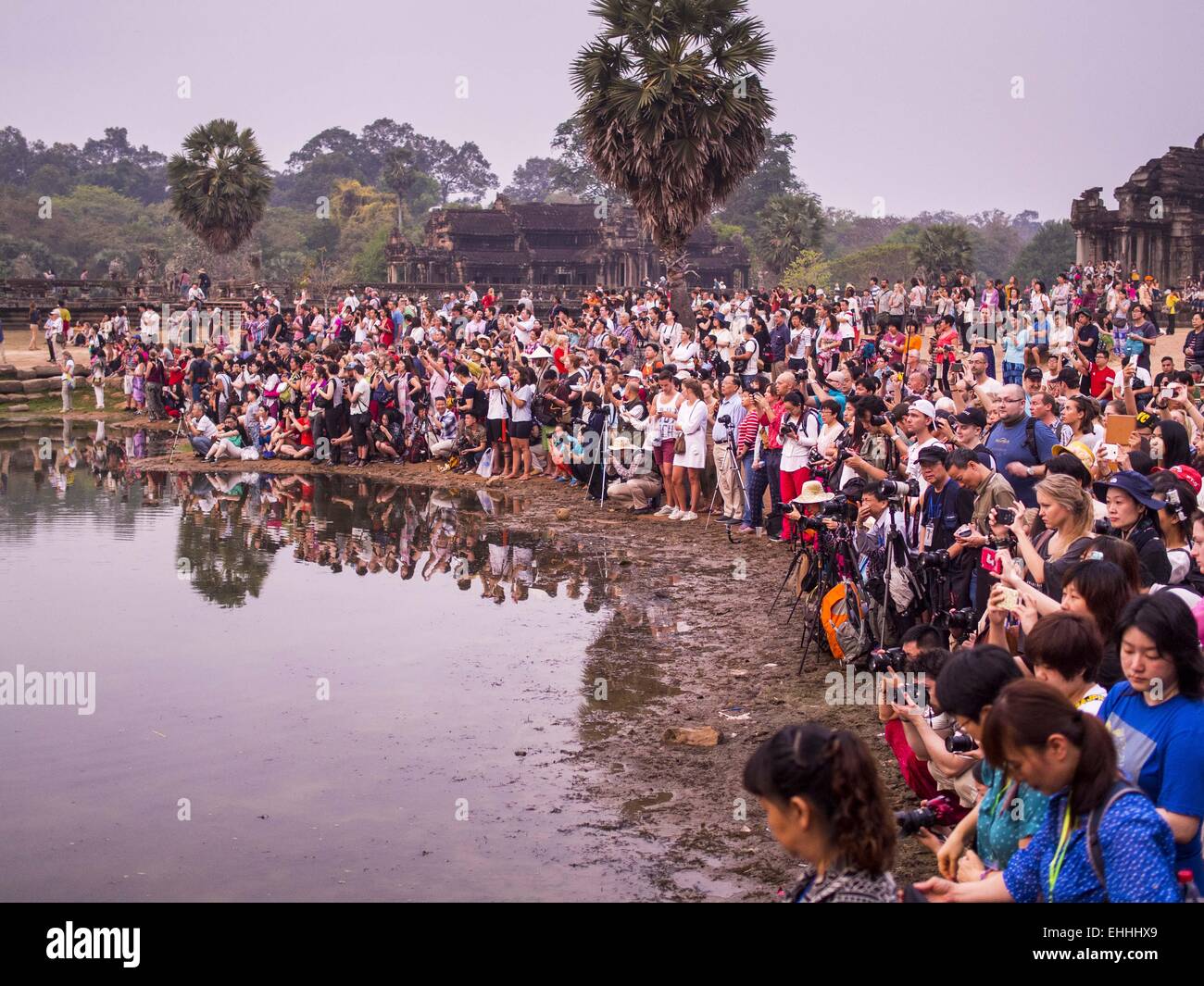 Seam Reap, Seam Reap, Cambodia. 14th Mar, 2015. Tourists gathered around the reflecting pool in front of Angkor Wat wait for the sunrise. The area known as ''Angkor Wat'' is a sprawling collection of archeological ruins and temples. The area was developed by ancient Khmer (Cambodian) Kings starting as early as 1150 CE and renovated and expanded around 1180CE by Jayavarman VII. Angkor Wat is now considered the seventh wonder of the world and is Cambodia's most important tourist attraction. © Jack Kurtz/ZUMA Wire/Alamy Live News Stock Photo