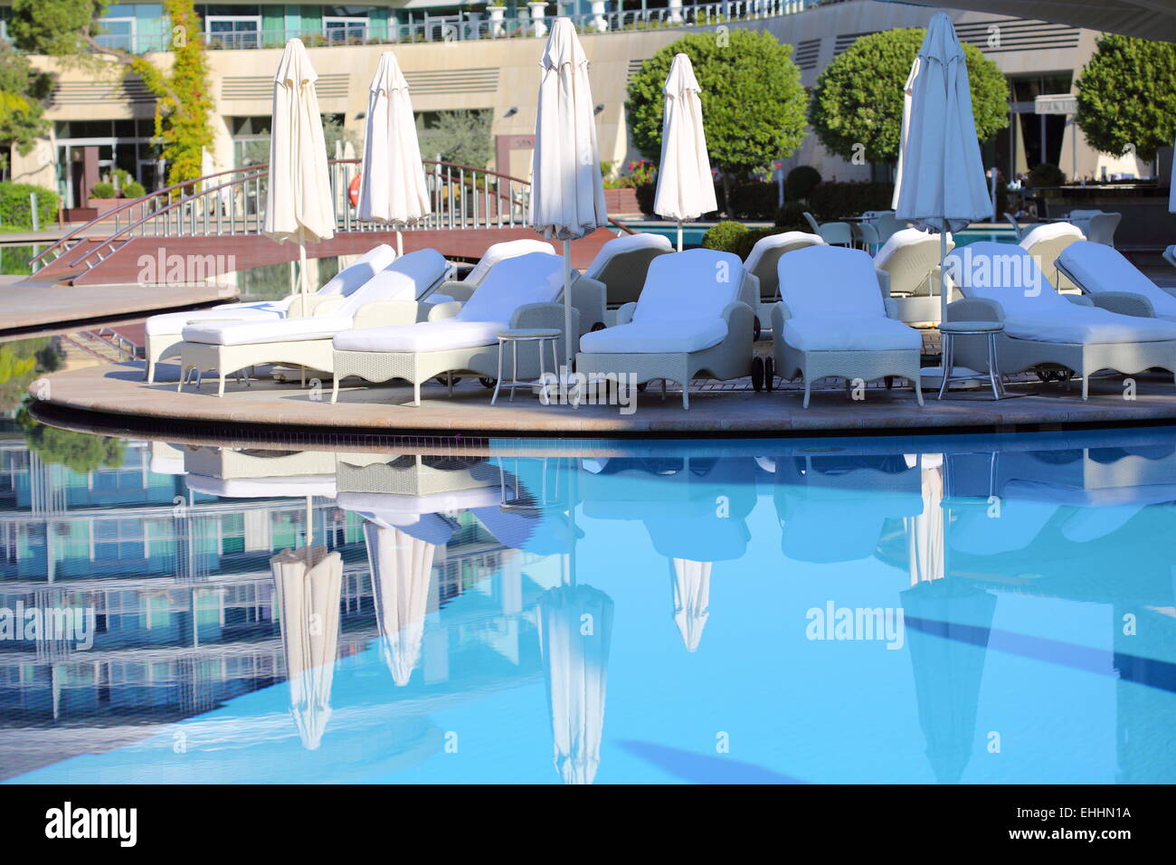 Beach chairs and umbrellas about pool Stock Photo - Alamy