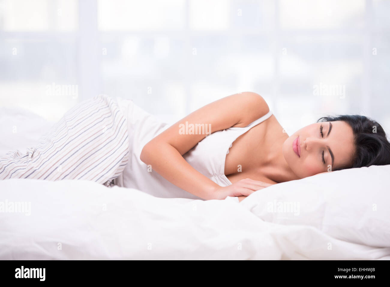 Beautiful woman in striped pyjamas on a Christmas Day Stock Photo - Alamy