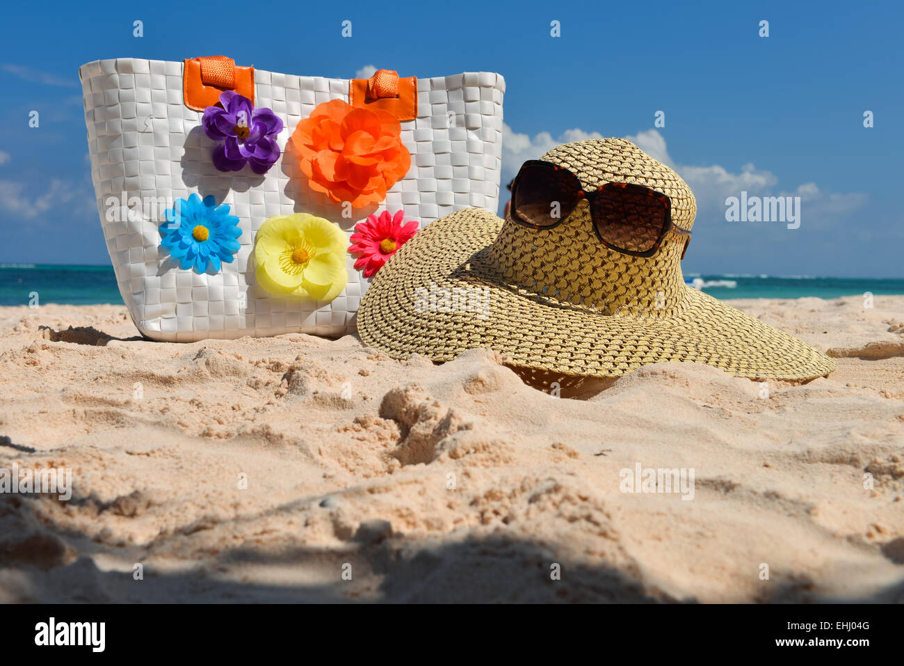 Summer beach bag with straw hat and sunglasses on sandy beach Stock Photo -  Alamy