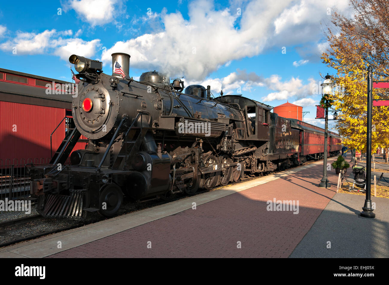steam engine train leaving the station full of tourists Stock Photo