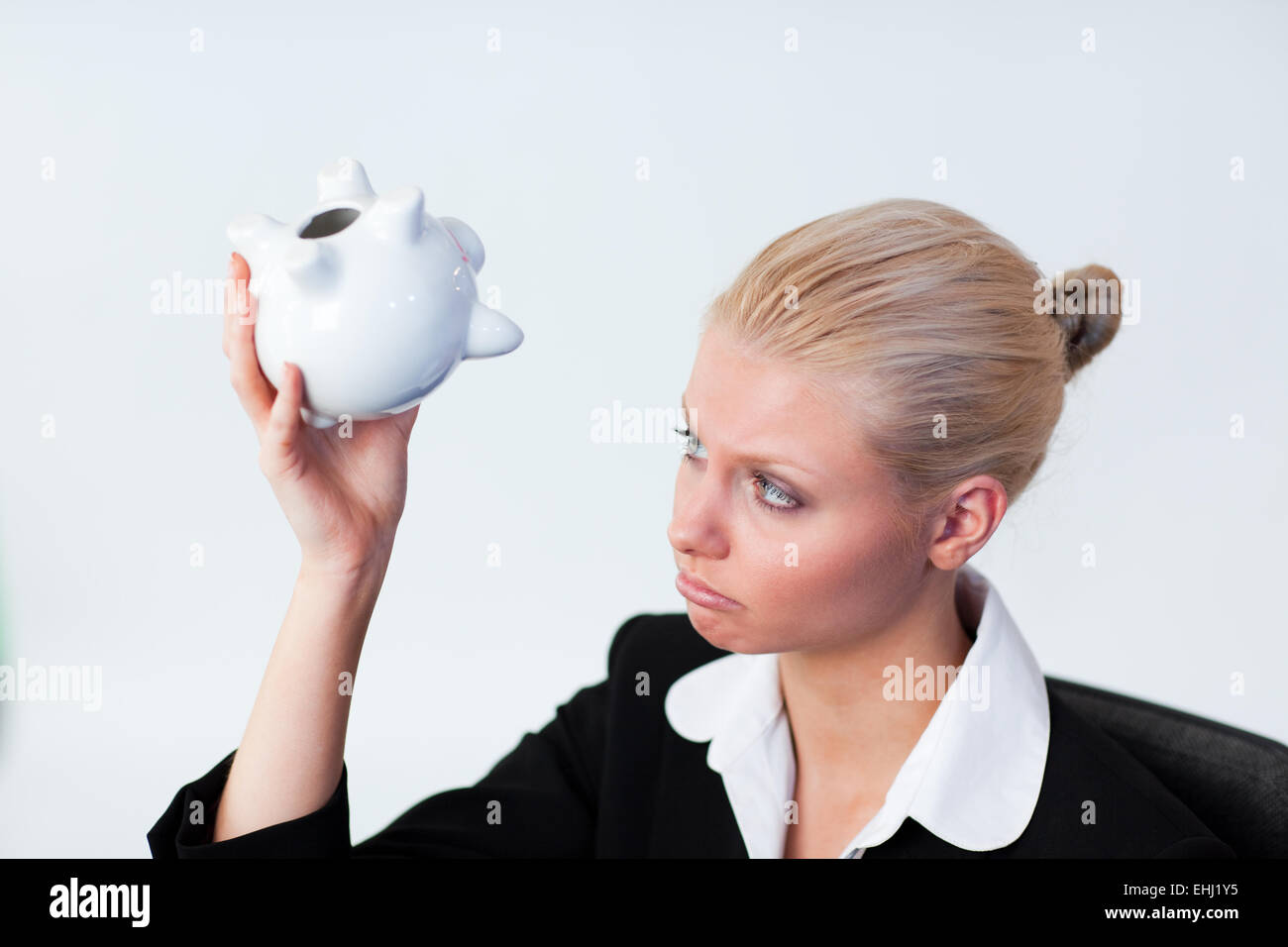 Sad Business woman looking into Piggy Bank Stock Photo - Alamy