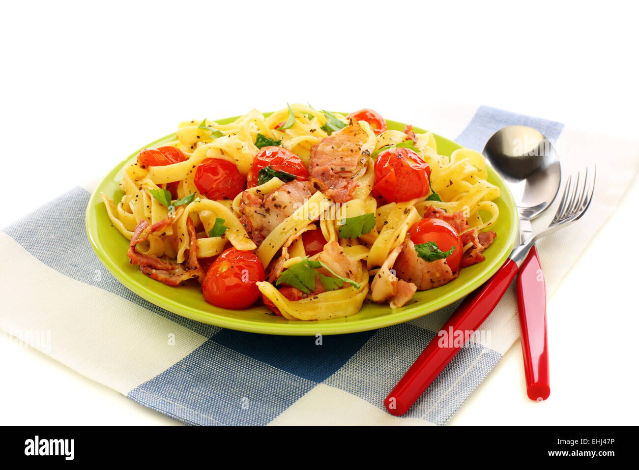 Pasta with bacon, tomatoes and basil. Stock Photo
