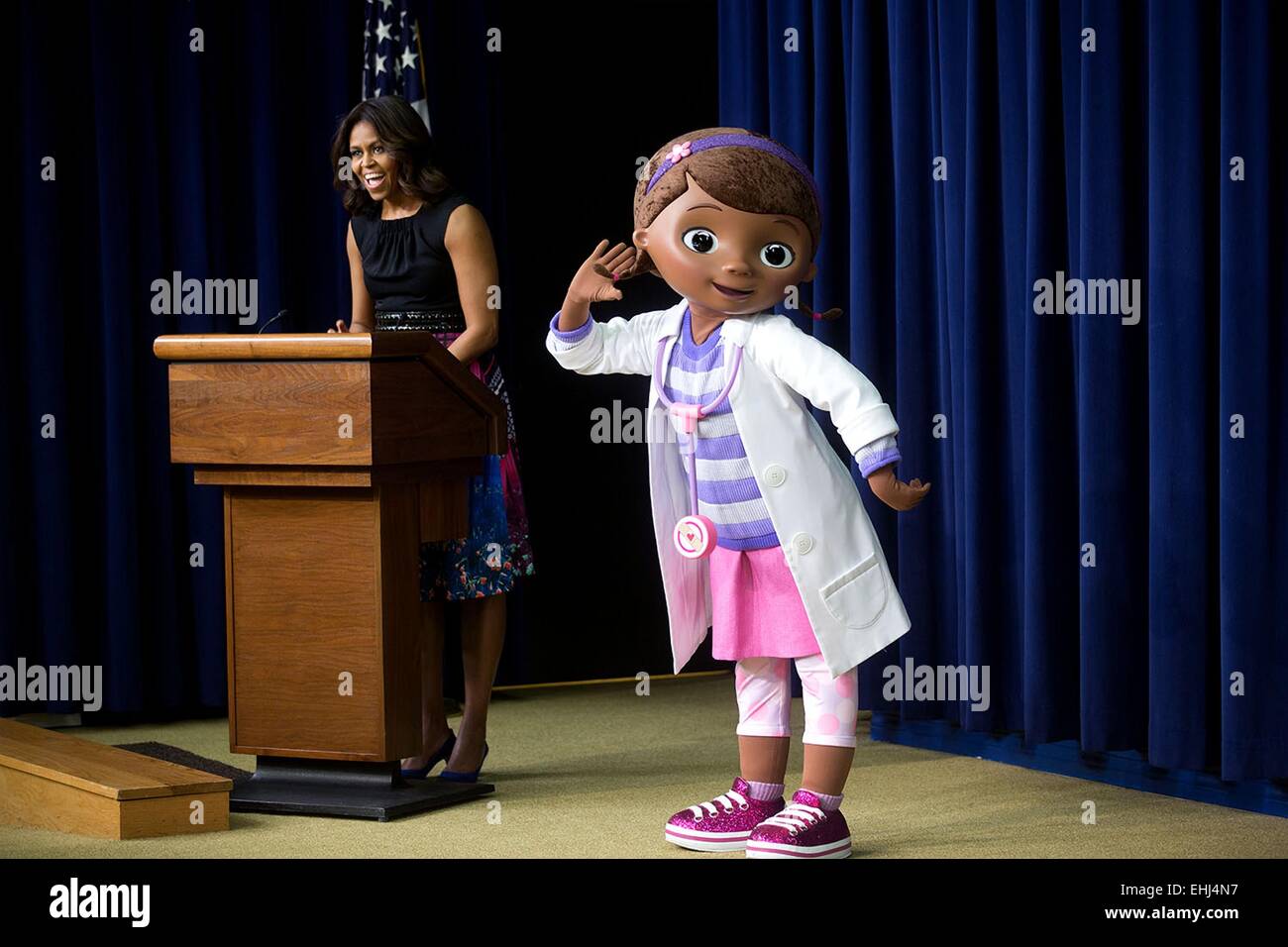 First Lady Michelle Obama delivers remarks to military children and families during a preview screening of a Veterans Day episode of Disney's 'Doc McStuffins,' that explores the emotions children face when a parent is deployed in the Eisenhower Executive Office Building South Court Auditorium November 10, 2014 in Washington, DC. Stock Photo