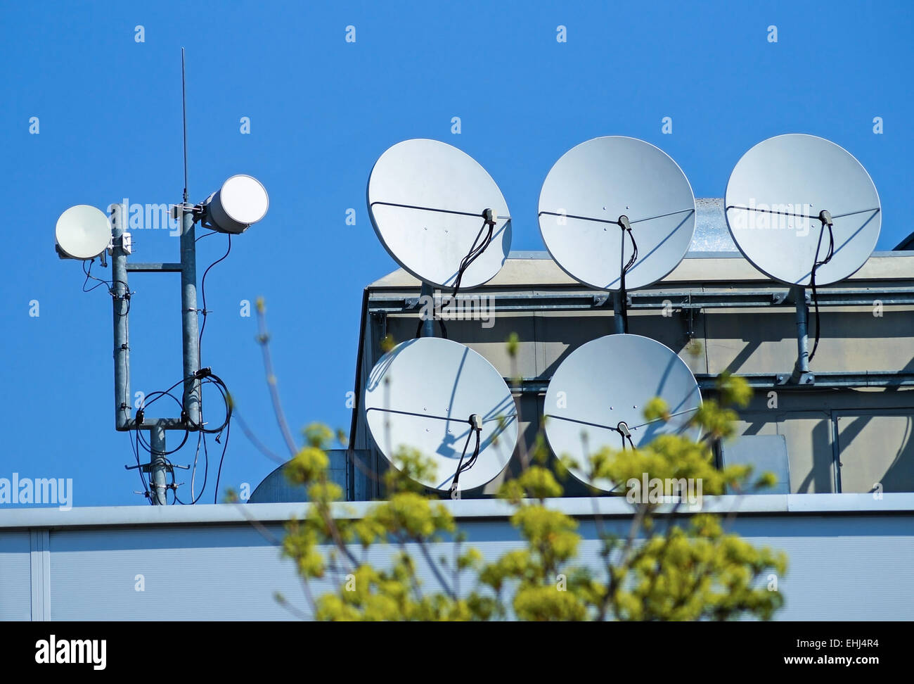 Satellite dishes on the top of a building Stock Photo
