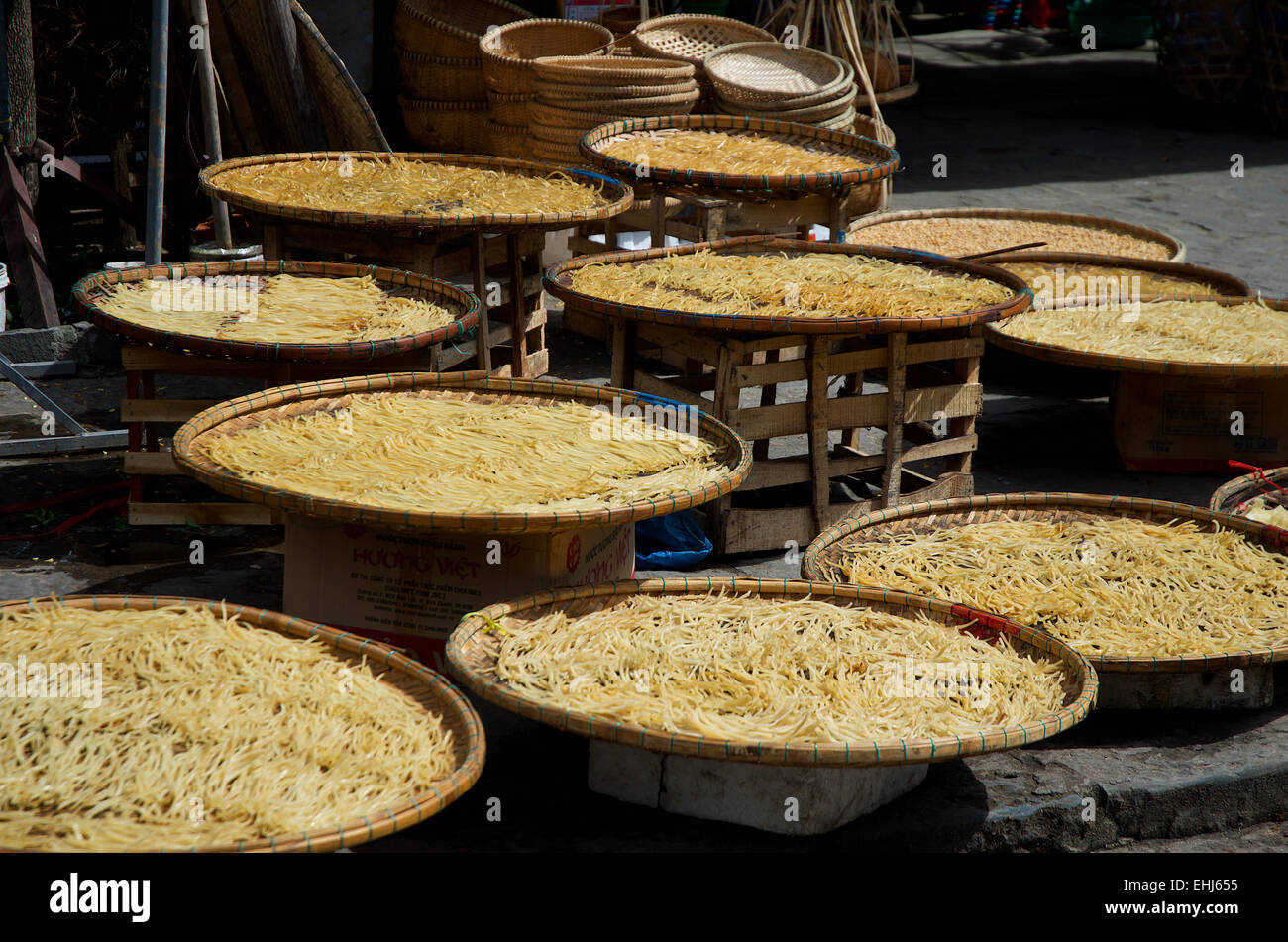 Big round baskets containing yellow vegetables at a market in Hoi An