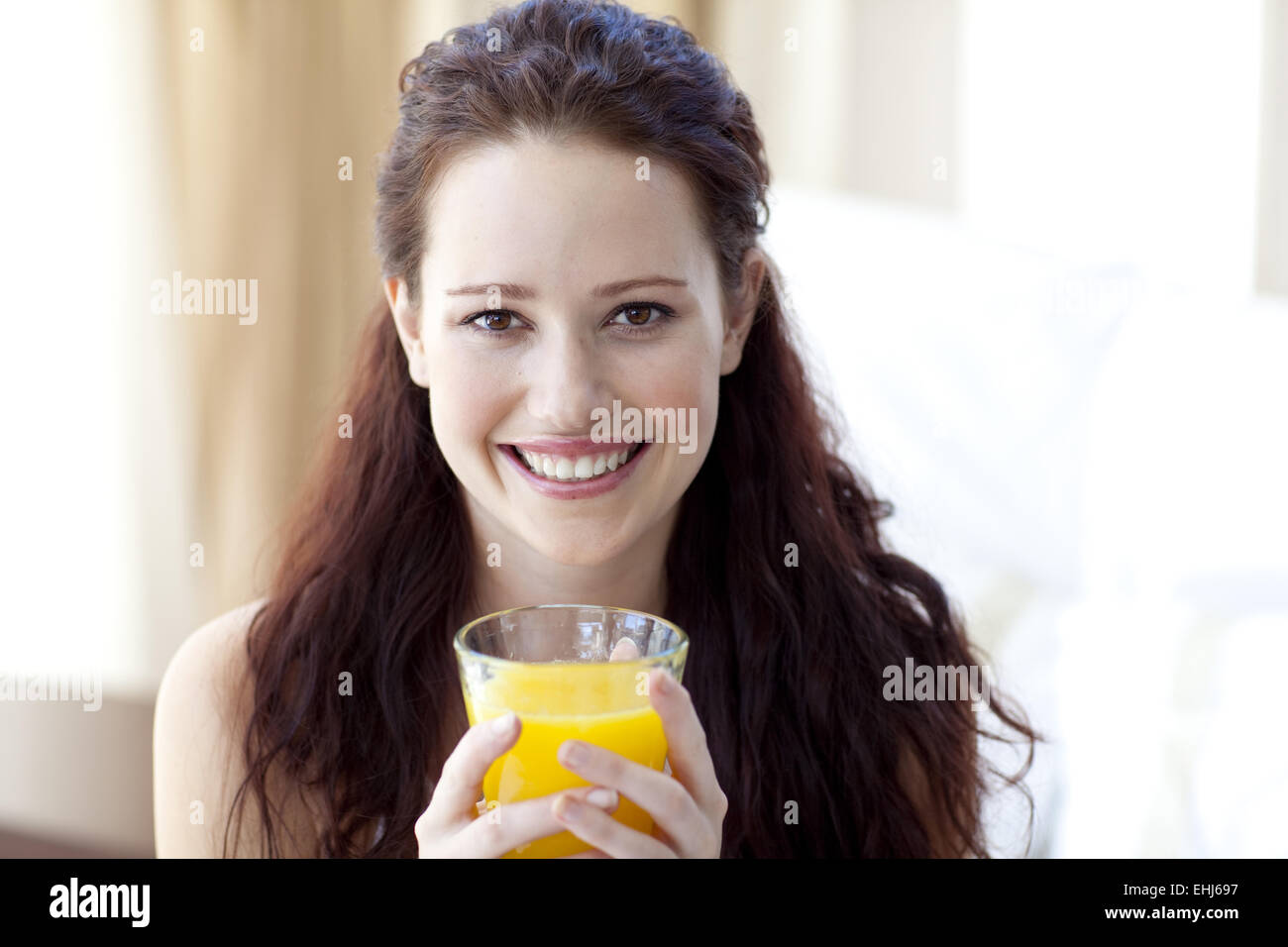 Girl drinking orange juice in bedroom Stock Photo Alamy