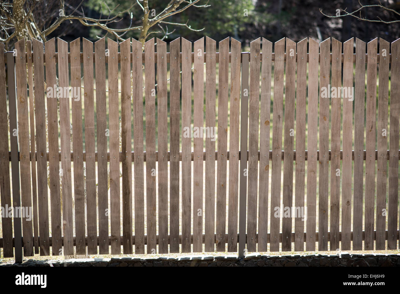 Beautiful wooden fence on a stone wall Stock Photo - Alamy