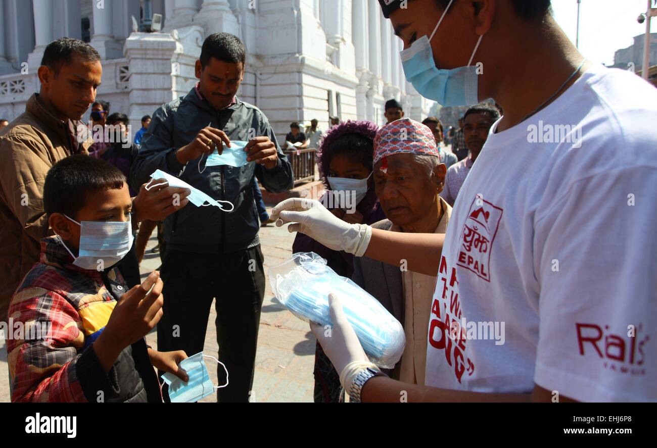 Kathmandu, Nepal. 14th Mar, 2015. A Nepalese youth distributes masks to passers-by during an awareness program about Swine Flu in Kathmandu, Nepal, March 14, 2015. People started to use masks frequently as two people have died and at least six people have been affected by Swine Flu virus with influenza A and B called (H1N1) in Kathmandu. © Sunil Sharma/Xinhua/Alamy Live News Stock Photo