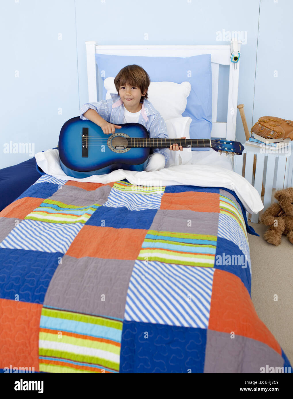 Little boy playing guitar in bedroom Stock Photo Alamy