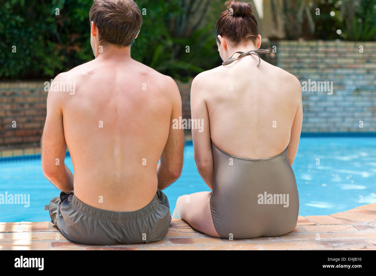 Couple sitting beside the swimming pool Stock Photo - Alamy