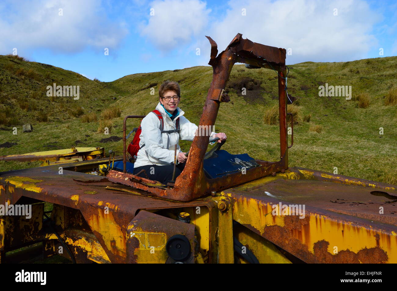 Woman driving old JCB digger on farmland on the Pennine Way. Stock Photo