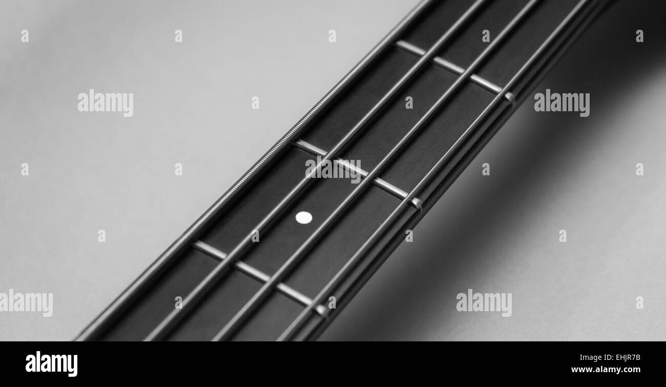 The fretboard of a four string graphite necked bass guitar Stock Photo