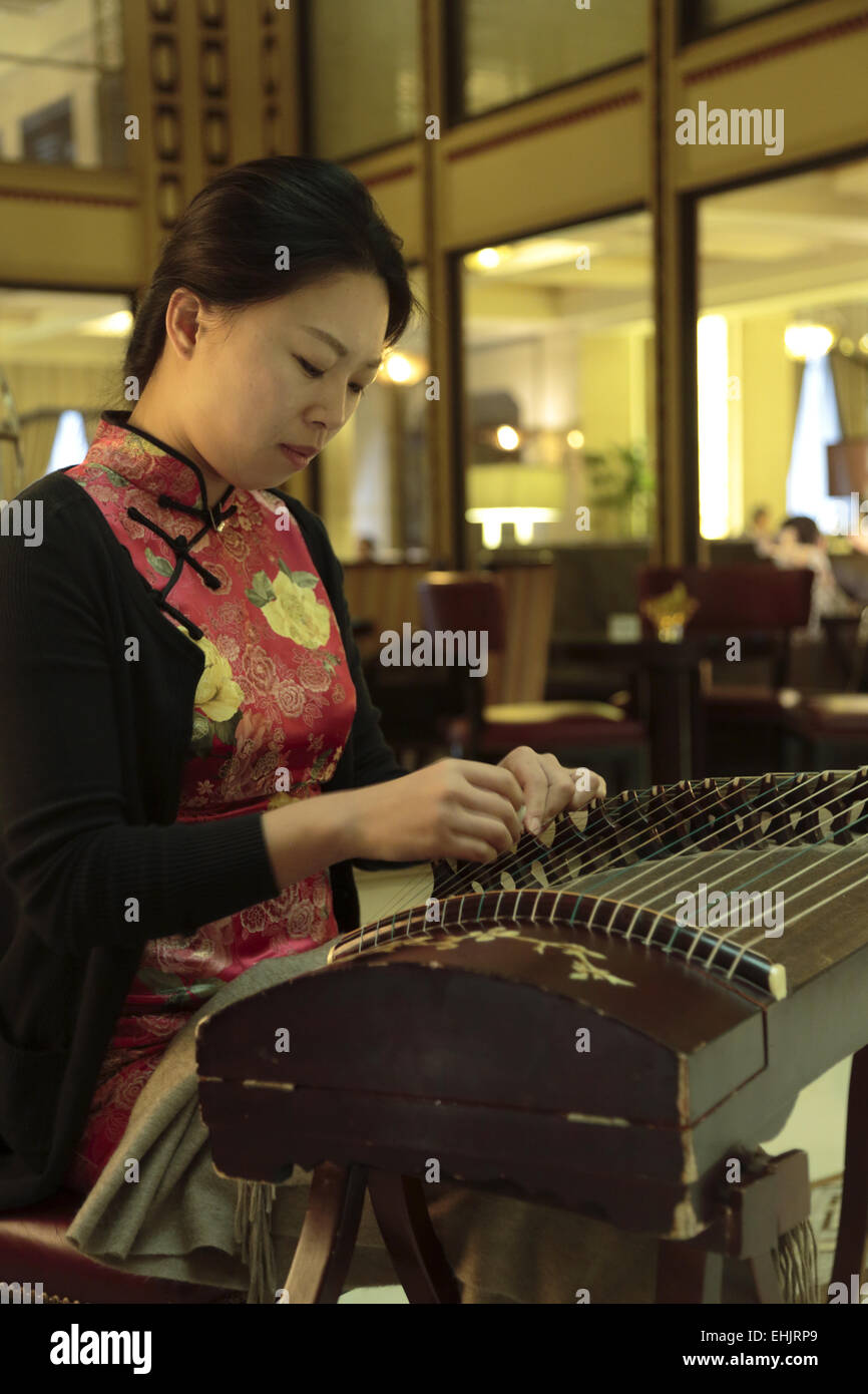 Woman playing a Guzheng a traditional Chinese music instrument in the