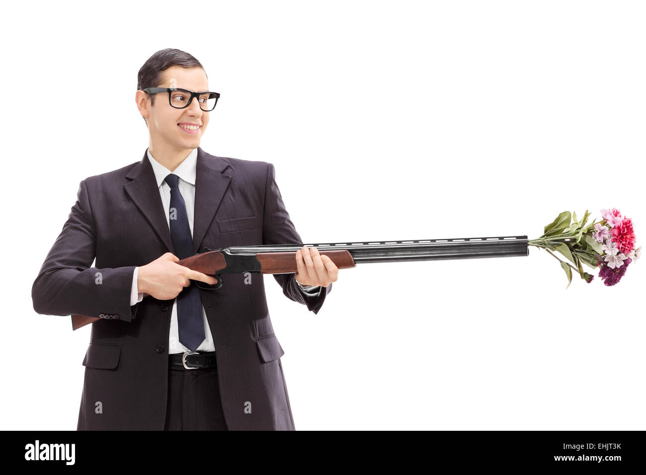 Businessman holding a rifle loaded with a bouquet of flowers isolated on white background Stock Photo