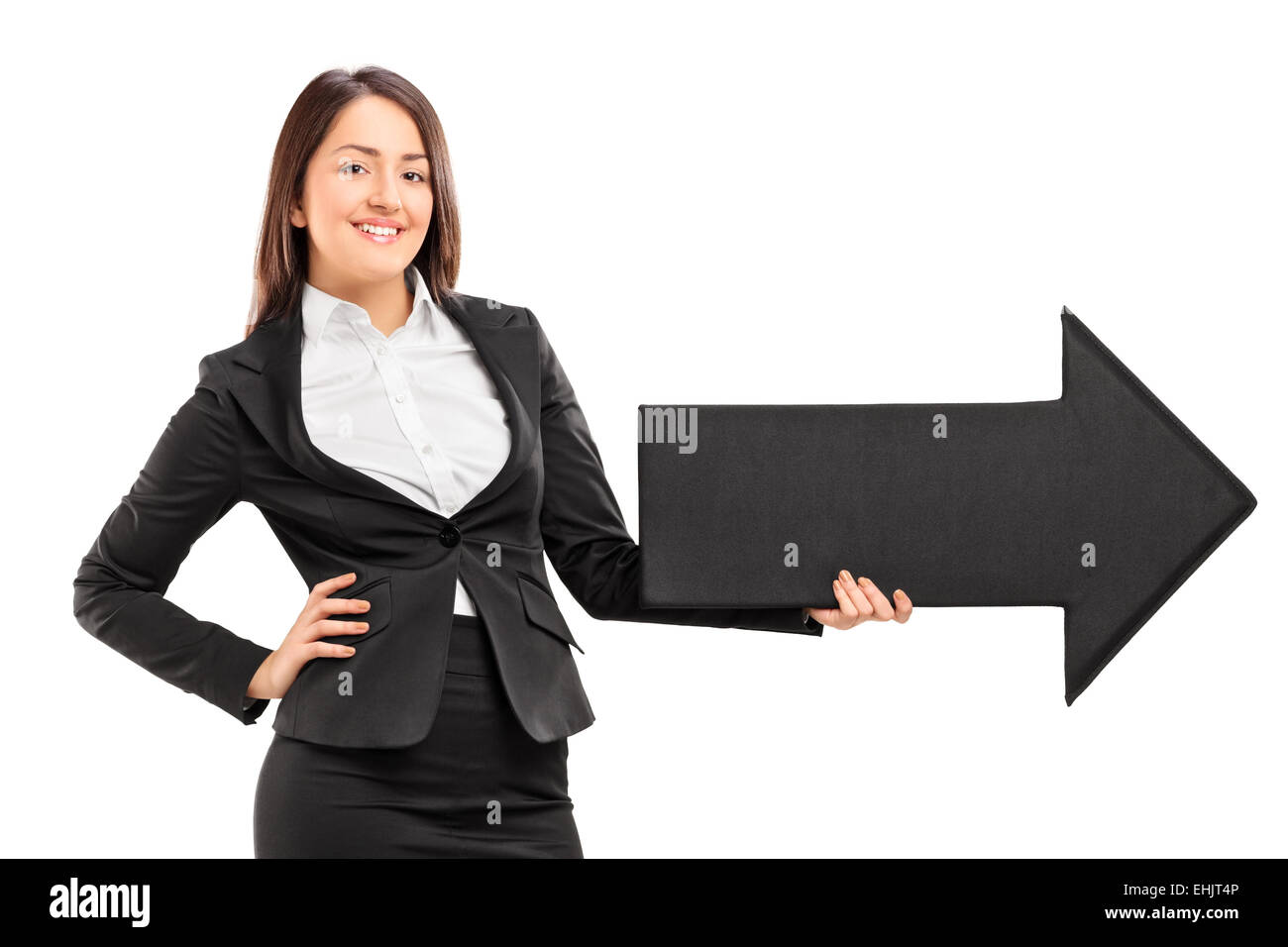 Smiling woman holding a big black arrow pointing right isolated against ...