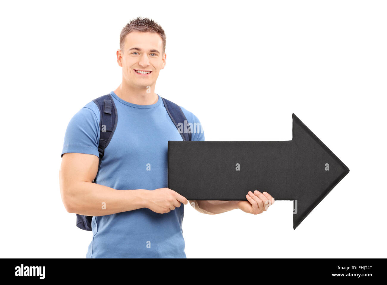 Young male student holding a big black arrow pointing right isolated on ...