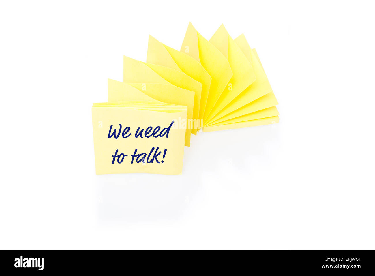 Yellow sticky note on block with message We Need To Talk Stock Photo