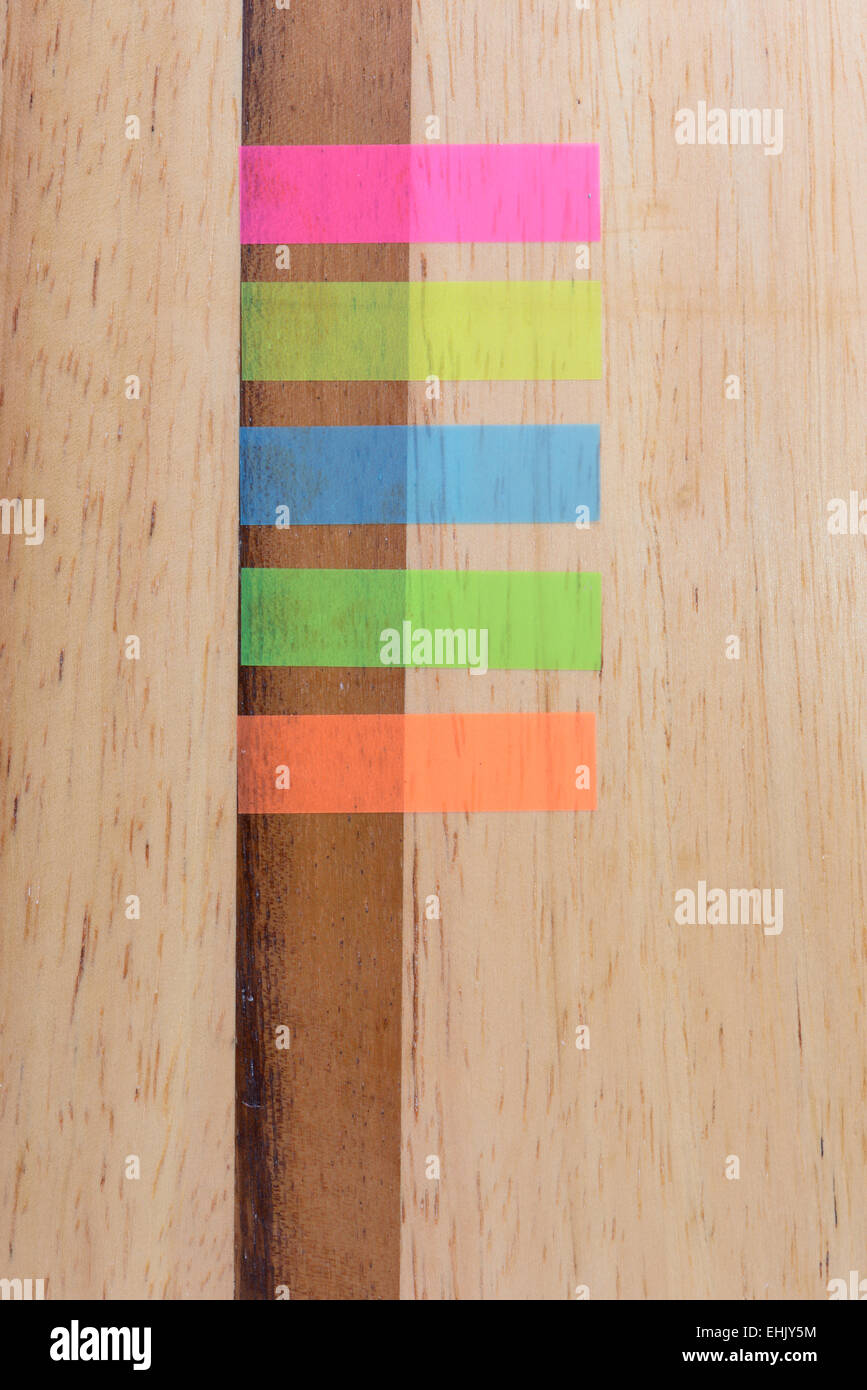 Notes five colours horizontal on wood background Stock Photo - Alamy