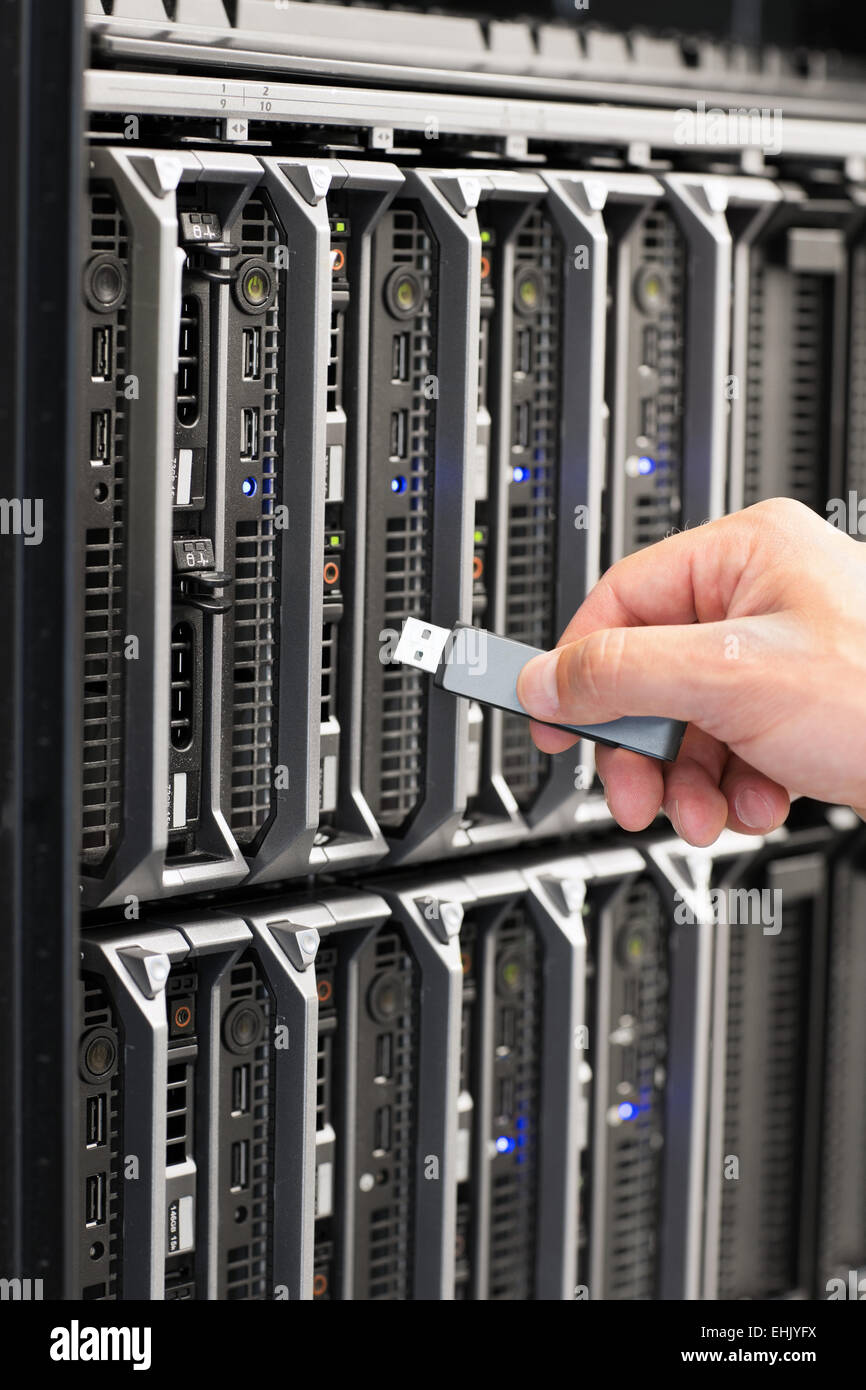 IT technician installs and maintain a blade servers in a data center. Plugs in a flash drive. Stock Photo