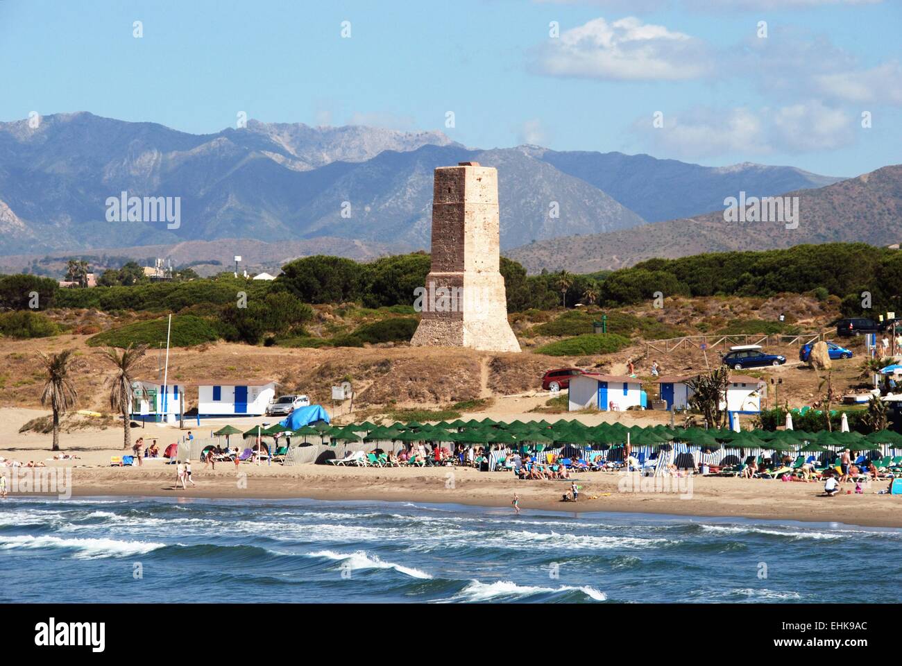 View of the beach with the watchtower and mountains to the rear, Puerto Cabopino, Costa del Sol, Malaga Province, Spain. Stock Photo