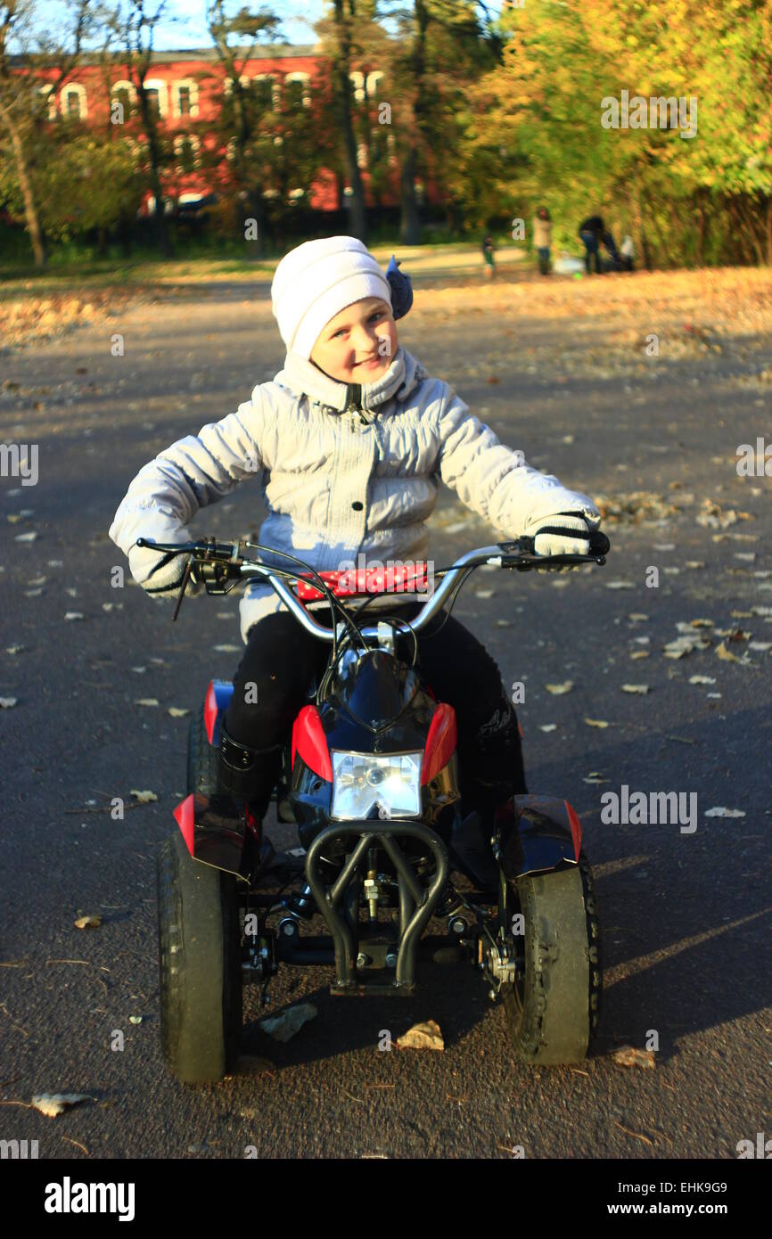 contented expression of little girl driving the electric toy car outside Stock Photo