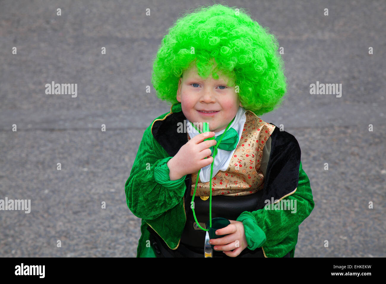 St. Patrick's Day wheelchair bound Daiton Berry Mellor (MR) 6 years old boy, a Spina bifida sufferer, wearing a green wig at the St Patrick's weekend Irish Festival.  Thousands of people lined the streets to watch as the St Patrick’s Day parade made its way through Manchester.  The colourful procession set off from the Irish World Heritage Centre in Cheetham Hill before making its way to Albert Square. Stock Photo
