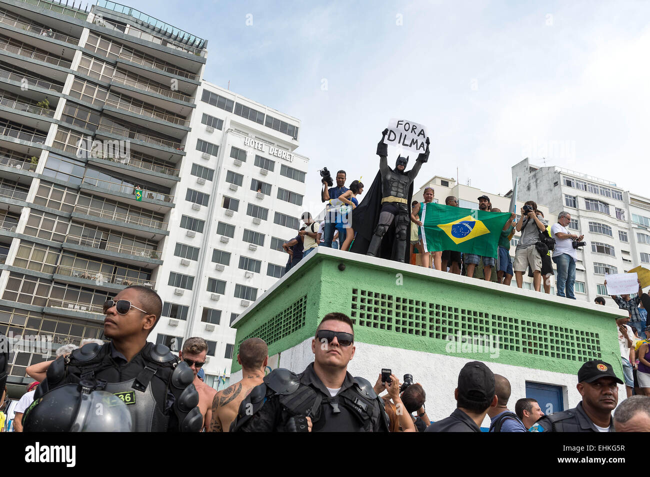 Rio De Janeiro, RJ, Brazil. 16th Mar, 2015. Eron Melo, famous and know as ''Batman'', who is going since 2013 to the streets to protest against corruption and bad government, is back on the streets today. Eron and his fellows are protesting on a roof of a building in Copacabana with posters and flags, ''DILAM OUT''.On Sunday, March 15th, a big crowd is gathering at Copacabana beach, south side of Rio City, Brazil. People from everywhere and all social classes, came to the streets to protest against Dilma Roussef, and are demanding her impeachment. They claim for justice, dignity, securit Stock Photo