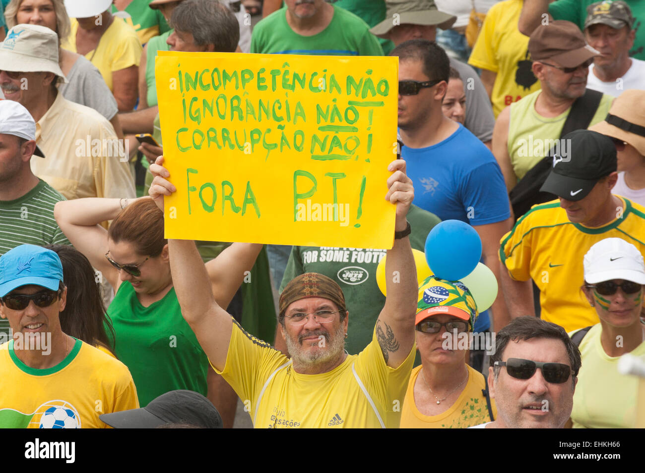 A protester carries a hand-written placard 'Incometence No, Ignorance No, Corruption No, PT [Workers' Party] Out'. Rio de Janeiro, Brazil, 15th March 2015. Popular demonstration against the President, Dilma Rousseff in Copacabana. Photo © Sue Cunningham sue@scphotographic.com. Stock Photo