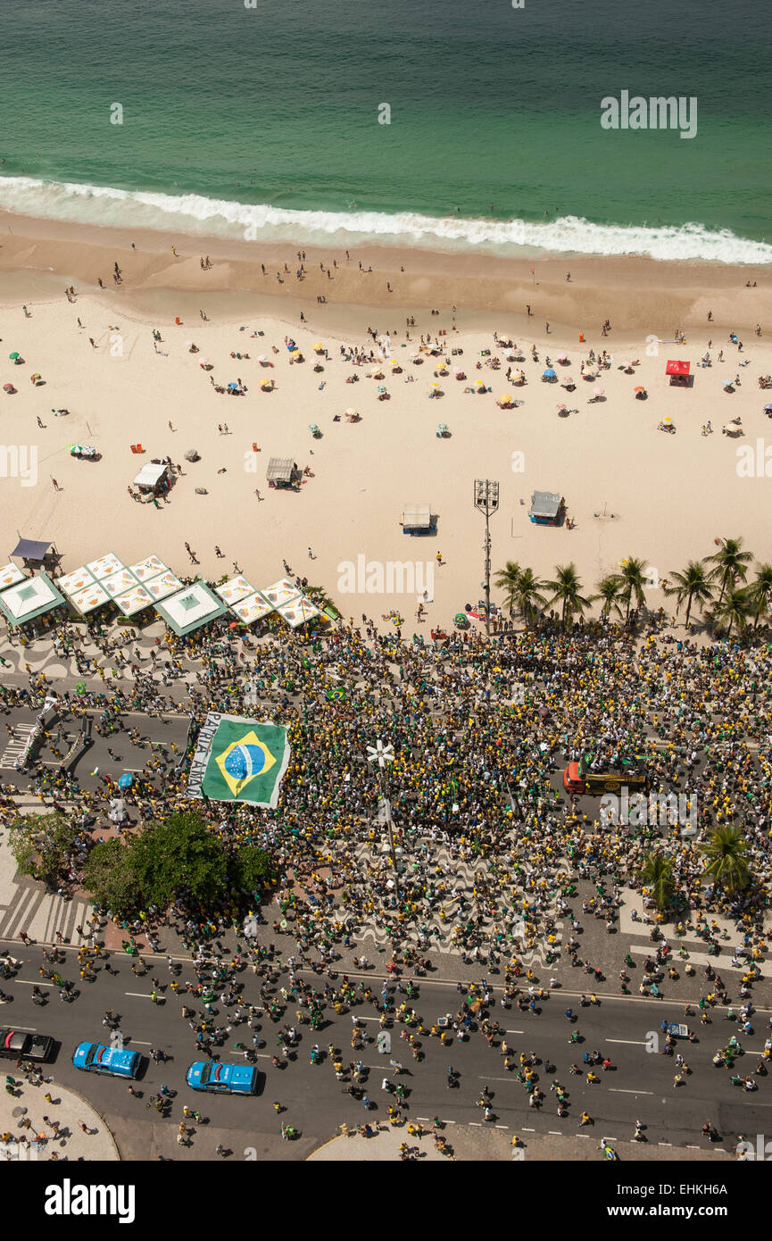 Protesters carry a huge Brazilian flag on the beach at Copacabana. Rio de Janeiro, Brazil, 15th March 2015. Popular demonstration against the President, Dilma Rousseff in Copacabana. Photo © Sue Cunningham sue@scphotographic.com. Stock Photo