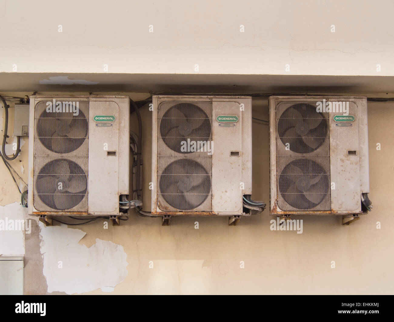 Electric air conditioning machines placed outside on a concrete building wall, necessary but not pretty, Coralejo Fuerteventura Stock Photo