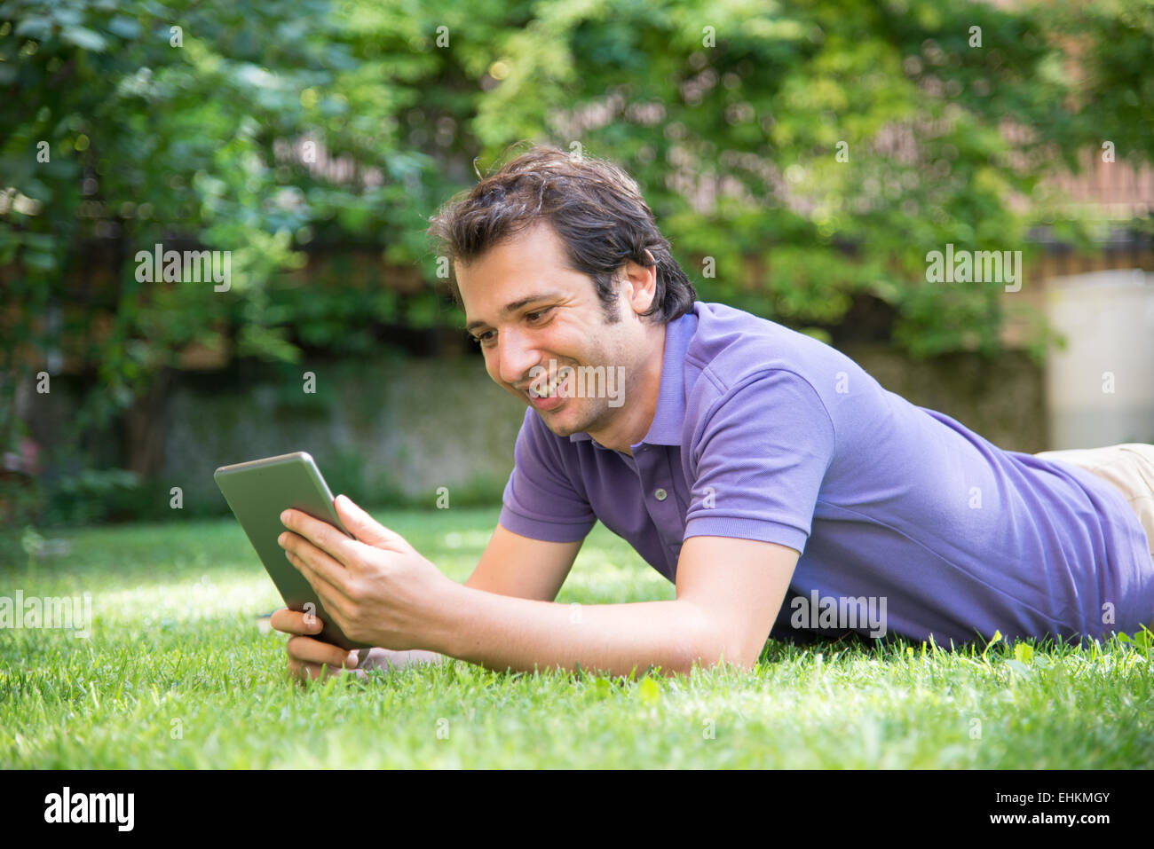 Smiling man working with a digital tablet Stock Photo