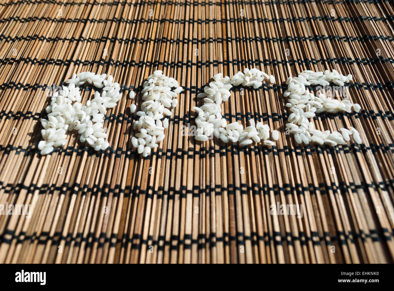 Sign 'rice' on a wicker placemat, written with rice grains Stock Photo