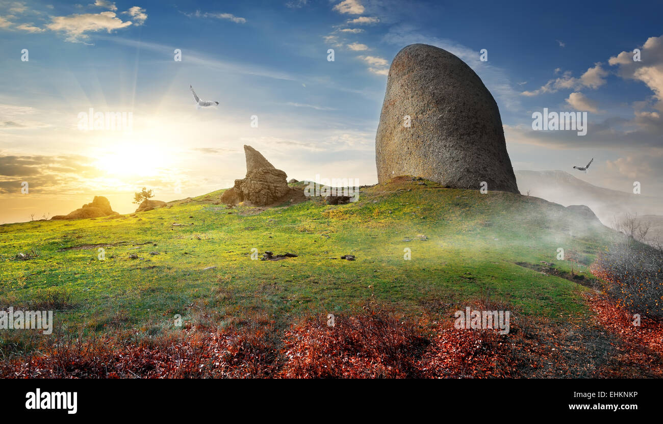 Birds over big stone on mountain in autumn Stock Photo