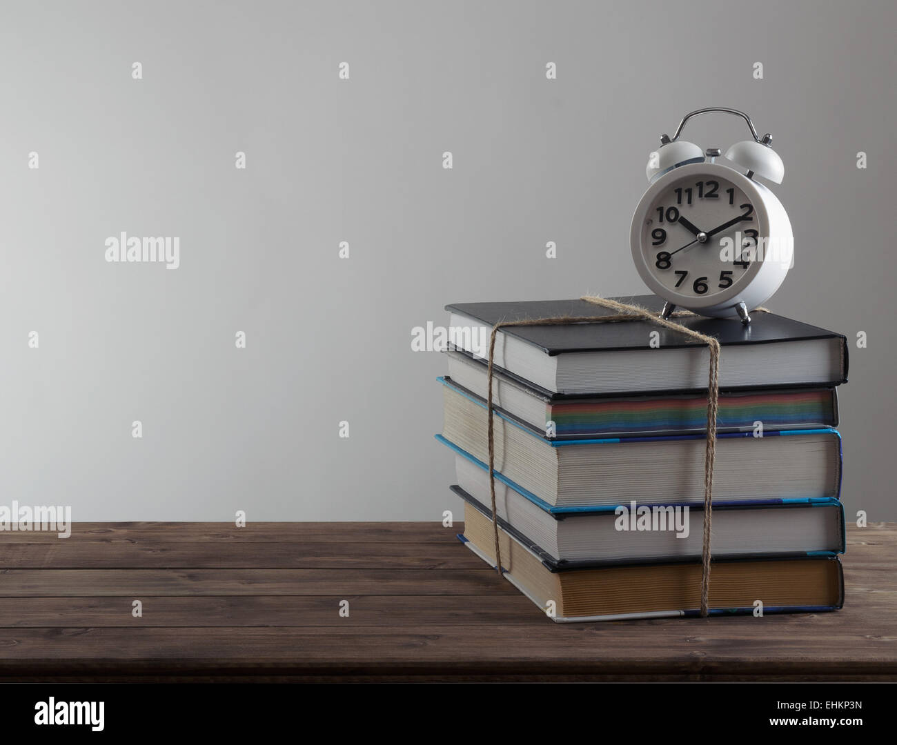 alarm clock stand on a pile of books Stock Photo Alamy