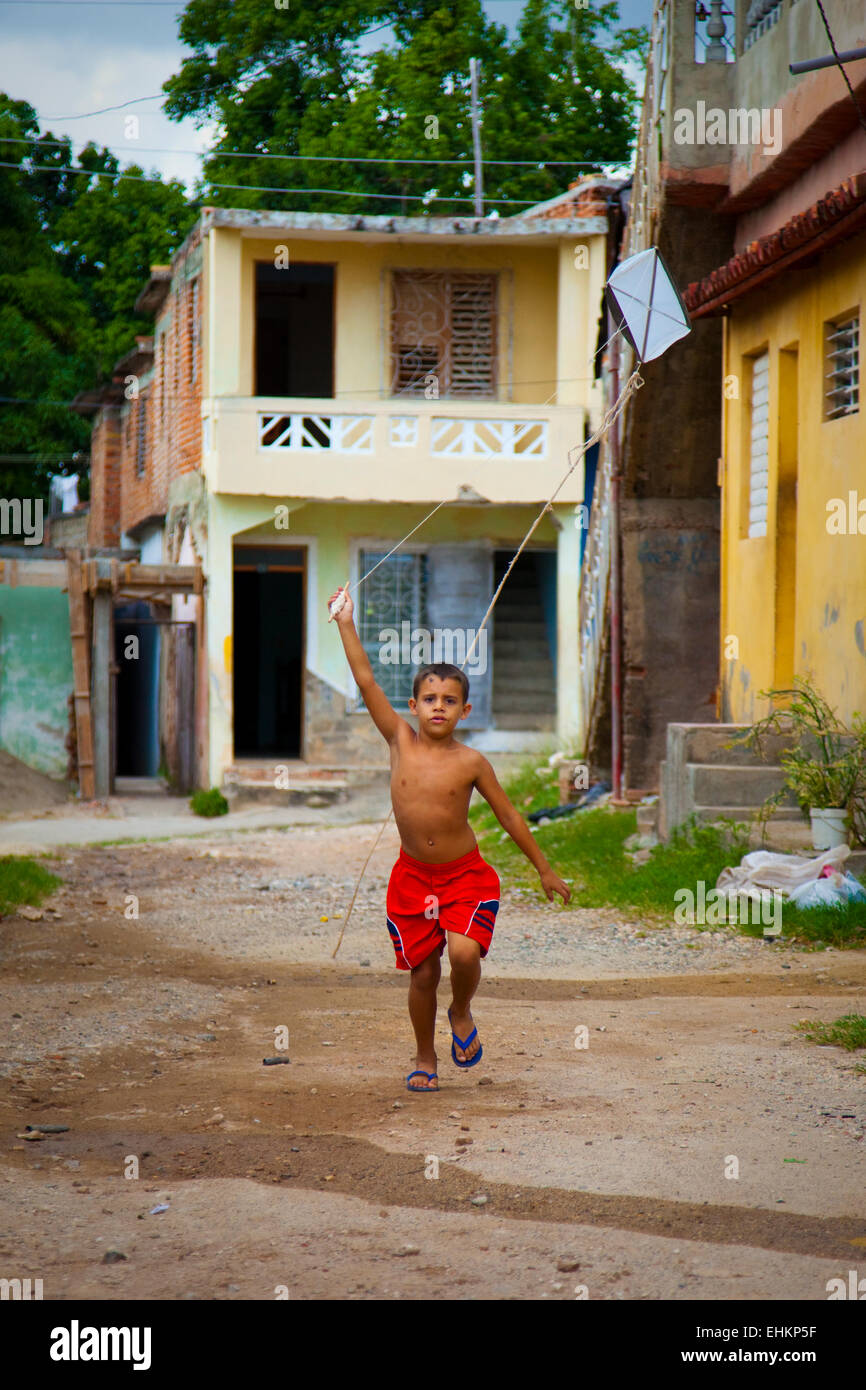 A boy flies a homemade kite in the street in Trinidad, Cuba Stock Photo