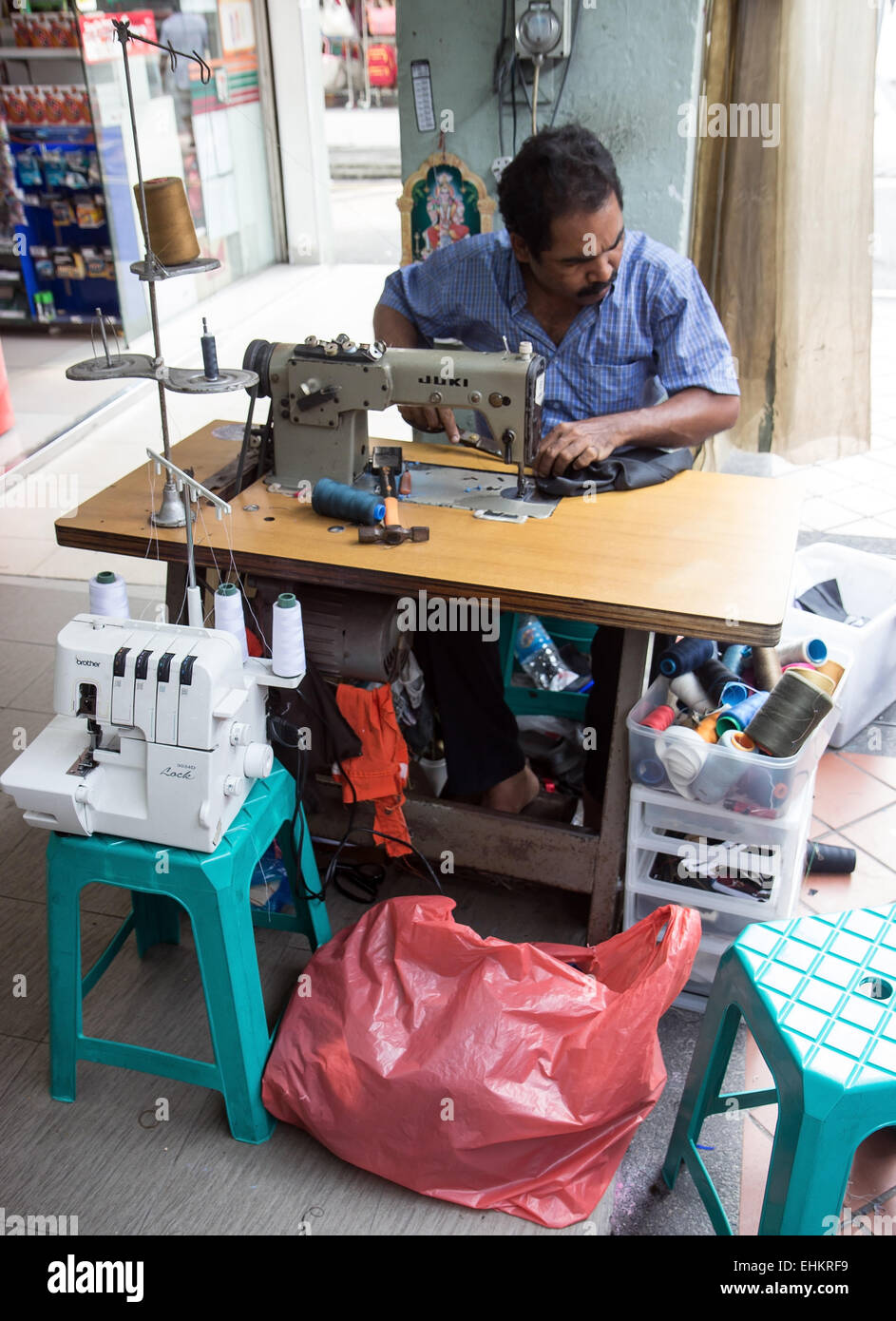 tailor working on a sewing machine on a street Stock Photo