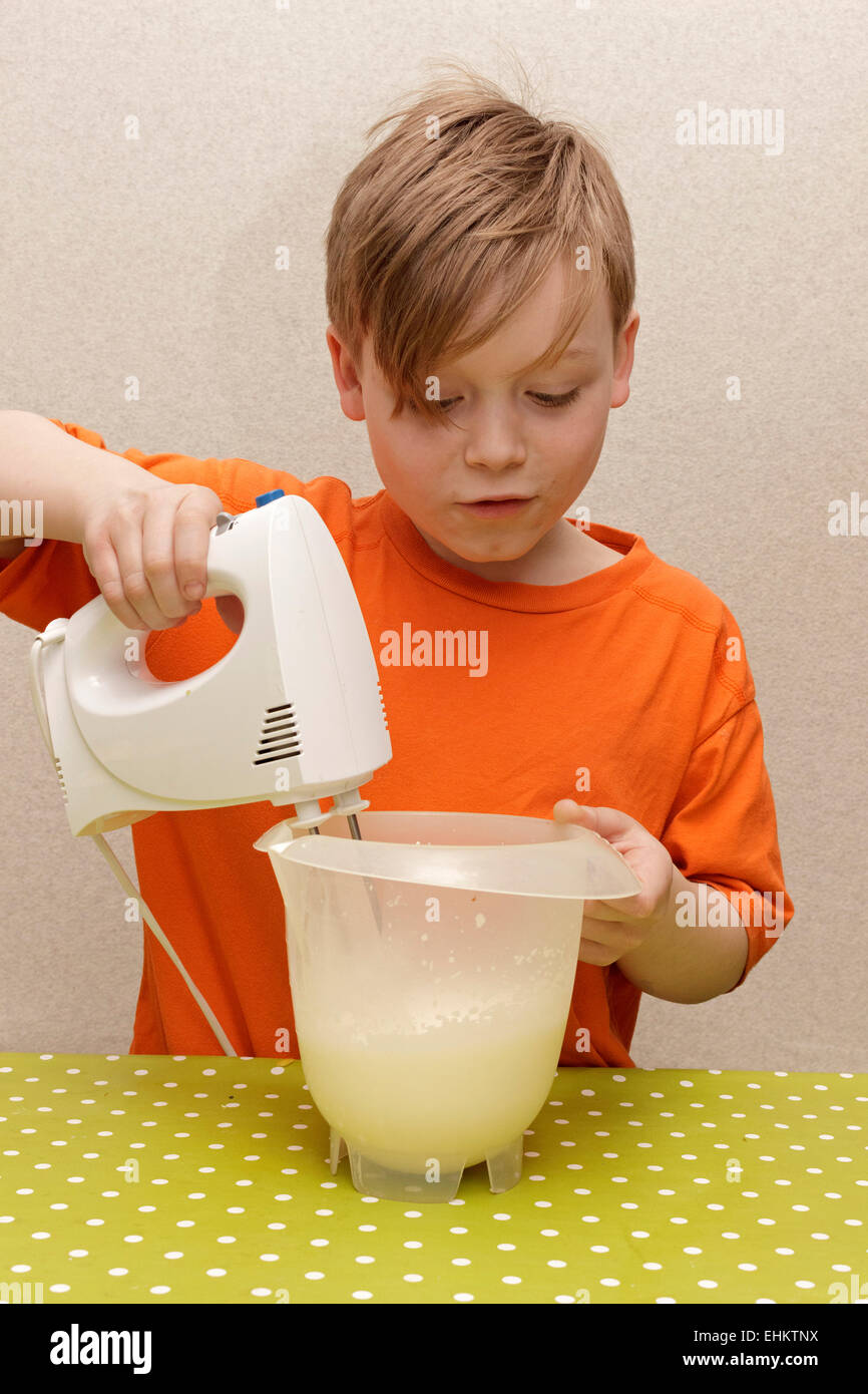 young boy making whipped cream Stock Photo