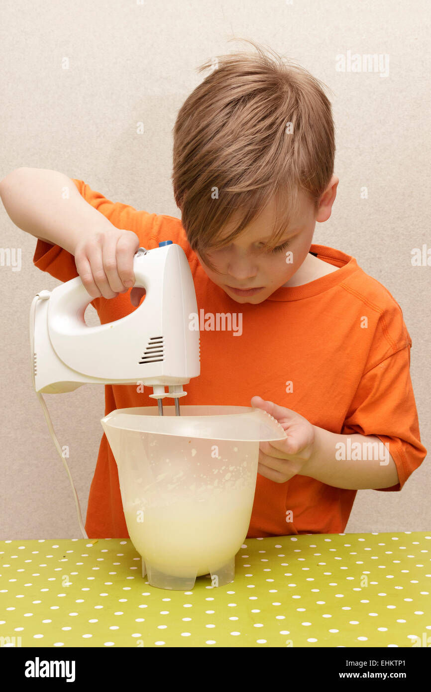 young boy making whipped cream Stock Photo