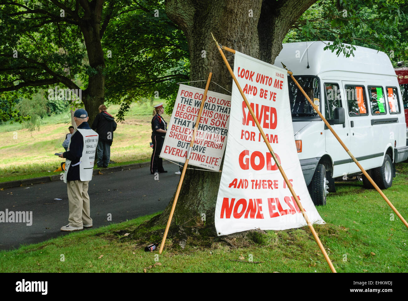 A man wearing a vest with bible verses hands out tracts to passersby Stock Photo